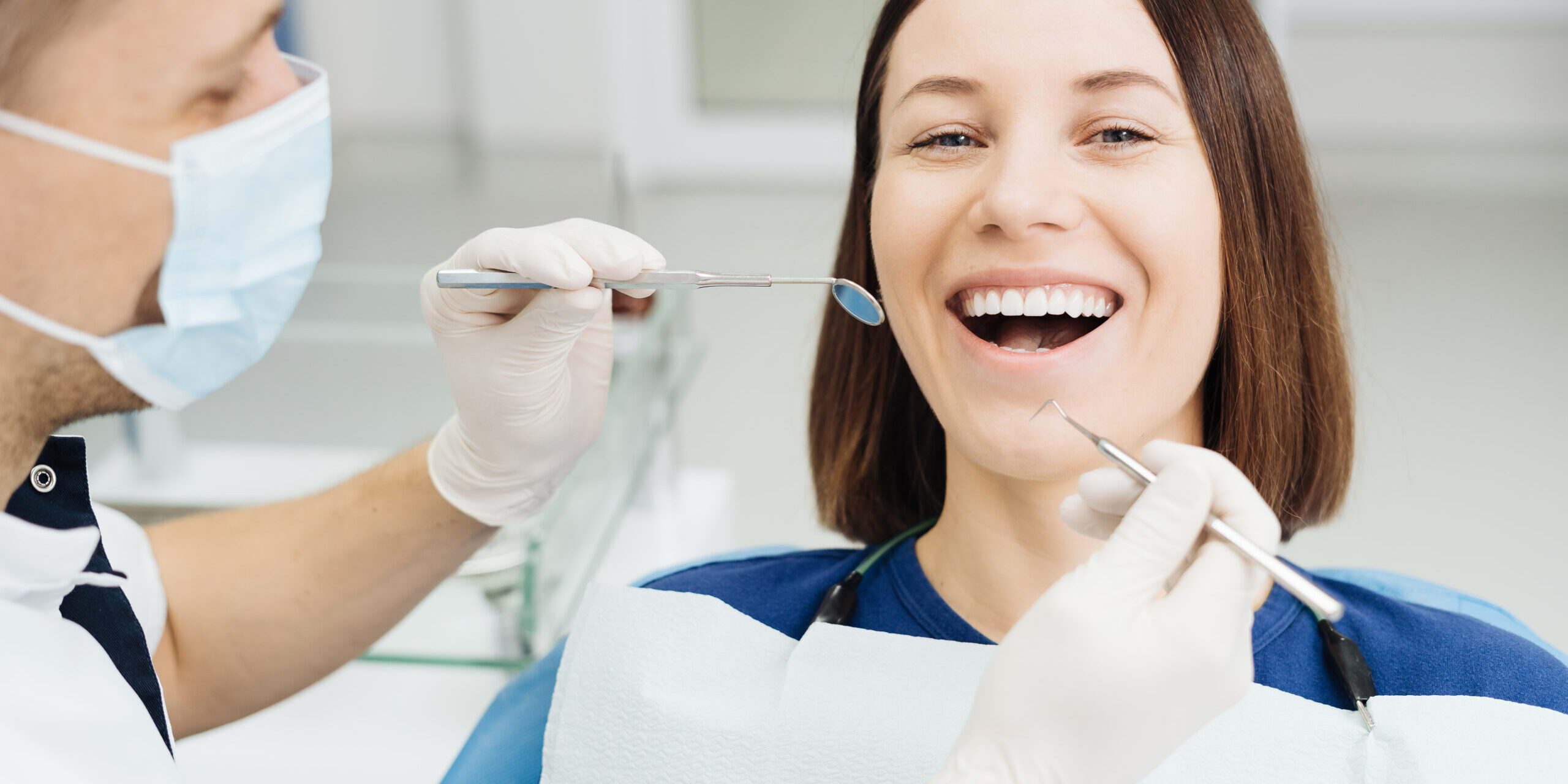 Dentist check patient cavity using instruments at clinic